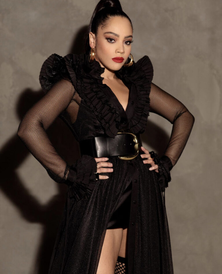 Bianca Lawson Posed for an Shoot Wearing a UNTTLD Black Ruffled Fishnet Mesh Dress With Berna Peci Gold Hoops and Nasty Gal Accessories
