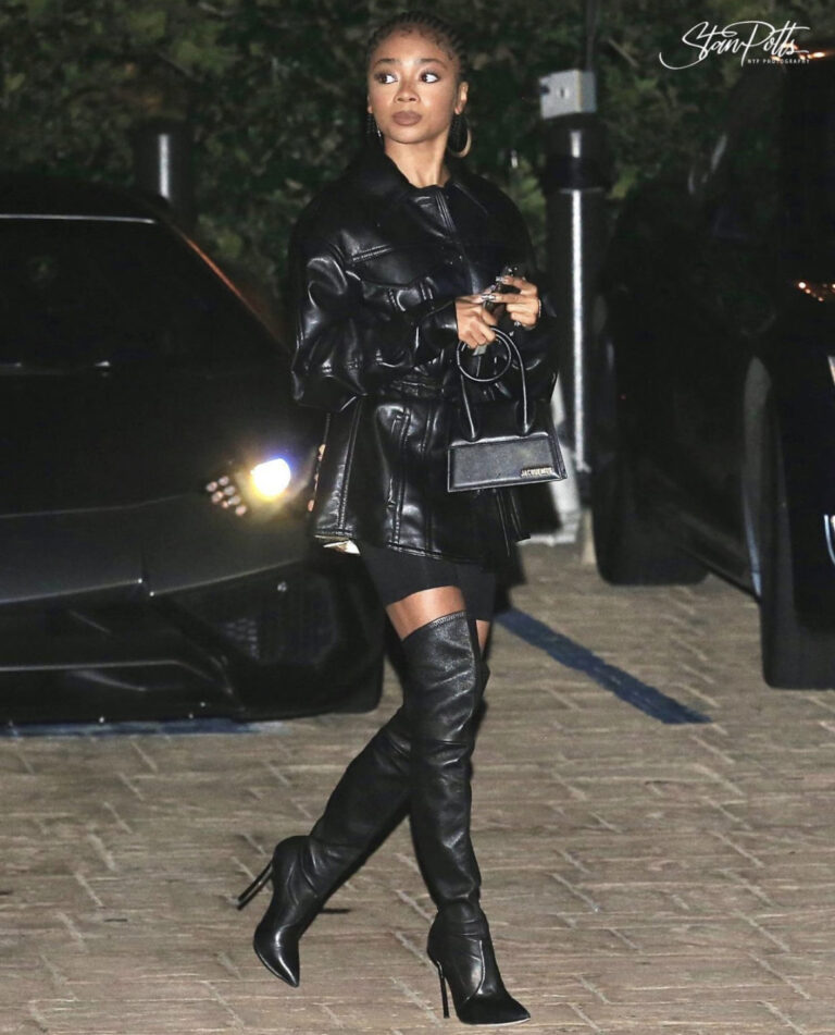 Skai Jackson Celebrates Her Birthday at NOBU Wearing Nanushka Black Oversized Belted Leather Shirt, Casadei Black Leather Thigh High Boots, and Jacquemus Black Medium Tote Bag